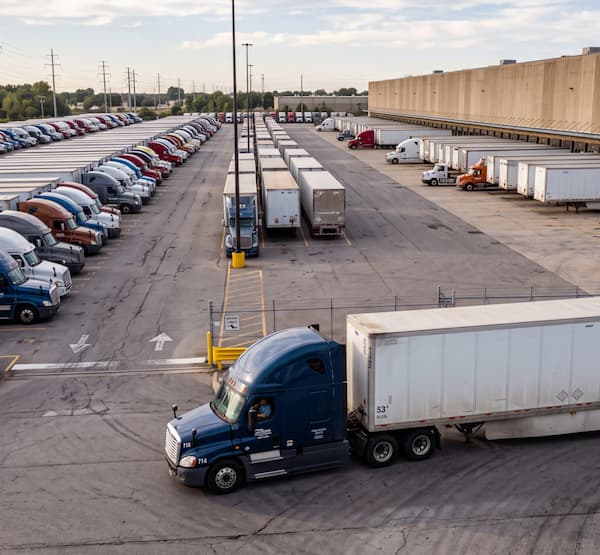 Truck driving in a parking lot full of parked trucks