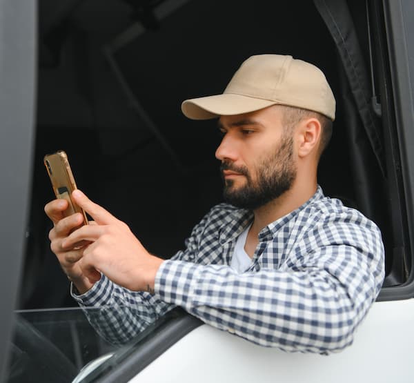 Truck driver in the driver's seat on their phone