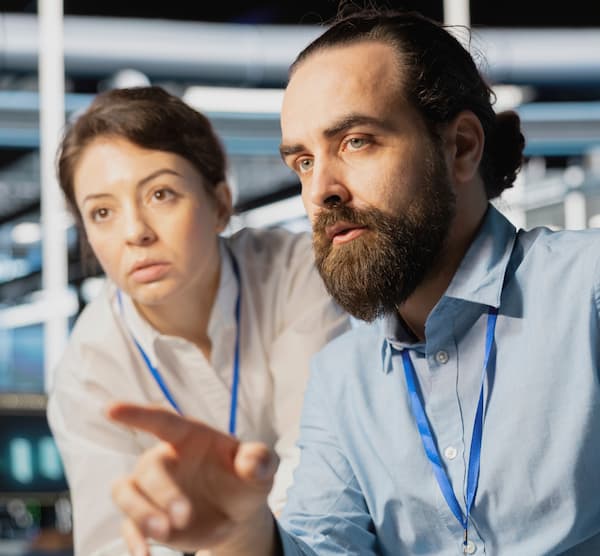 Two office workers looking at something off screen