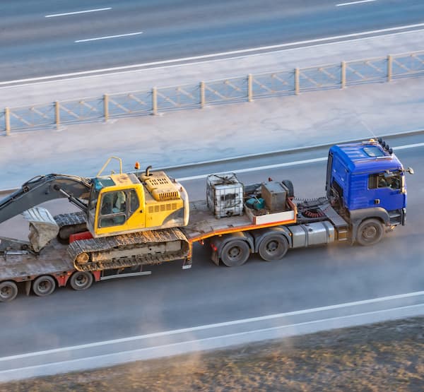 Truck on a highway hauling construction machinery