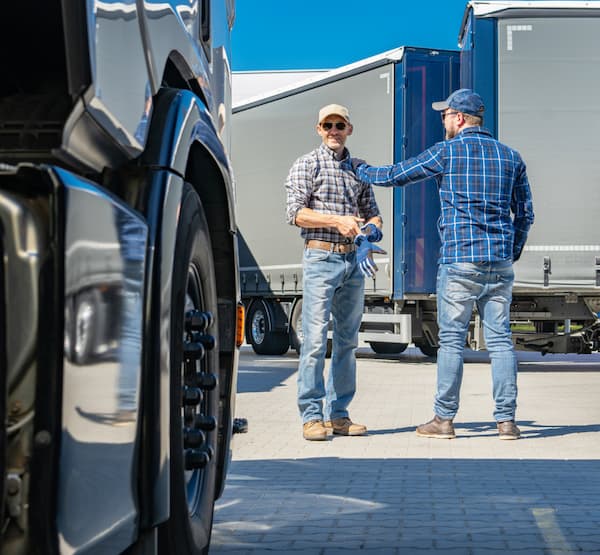 Two men standing in front of a parked truck