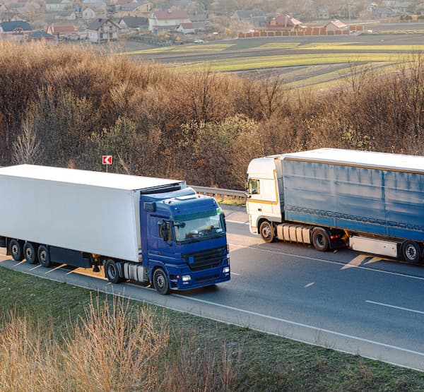 Two trucks going opposite directions on the road